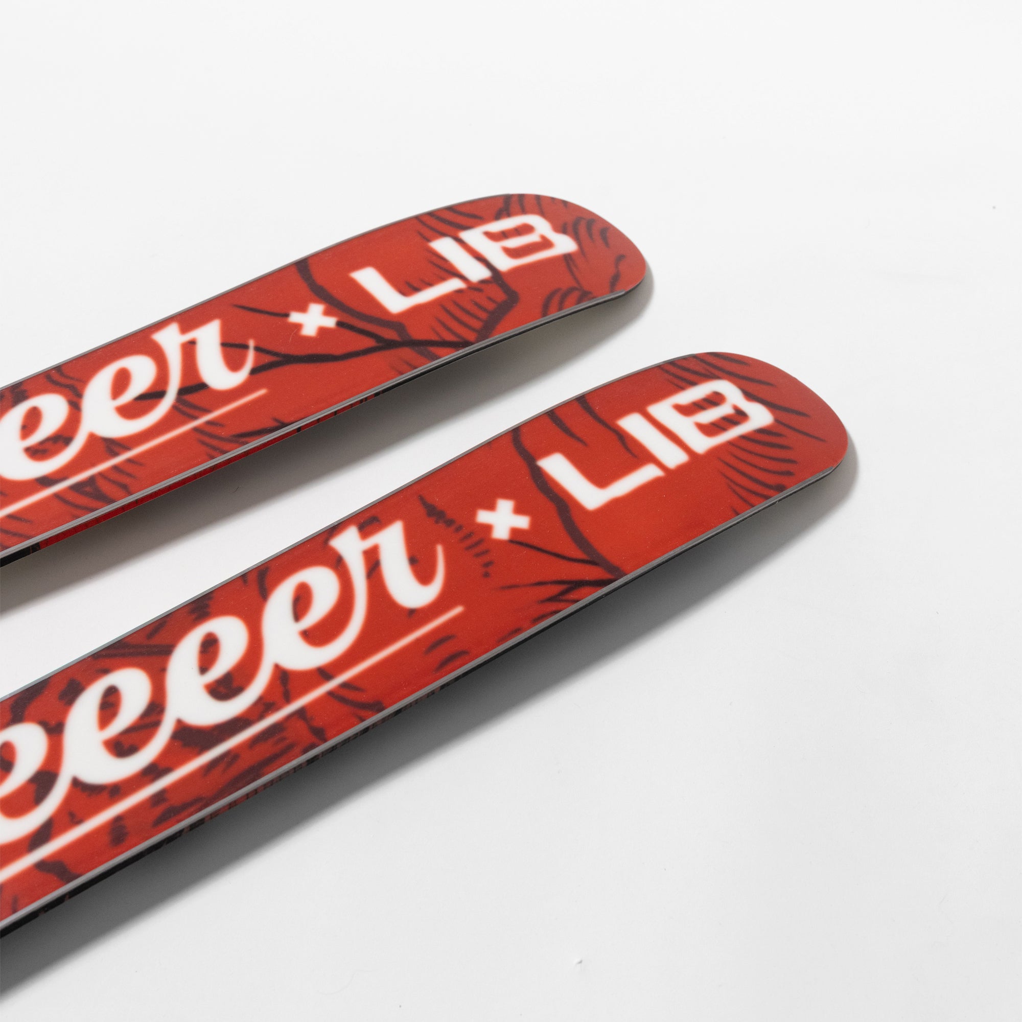 Two red skis with white text on a light gray background